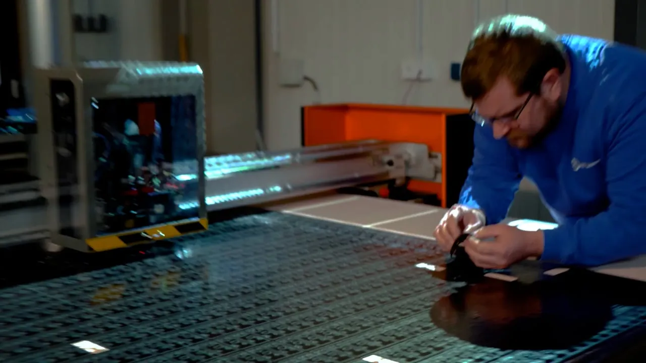 Mitarbeiter von AET Lézaud prüft ein Bauteil an der Maschine in der Produktion