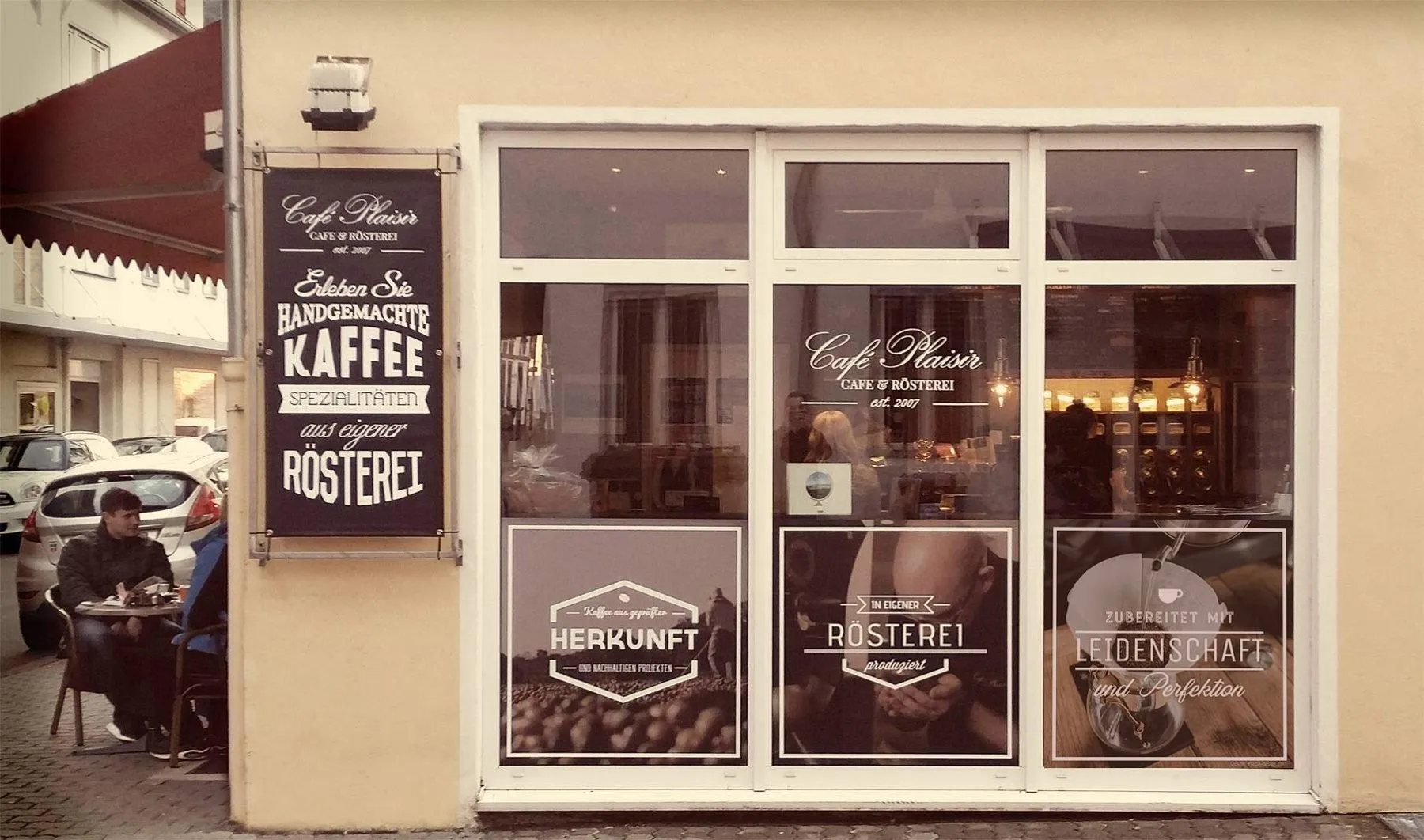Schaufenster der Plaisir Kaffeerösterei mit Fensterbeschriftung
