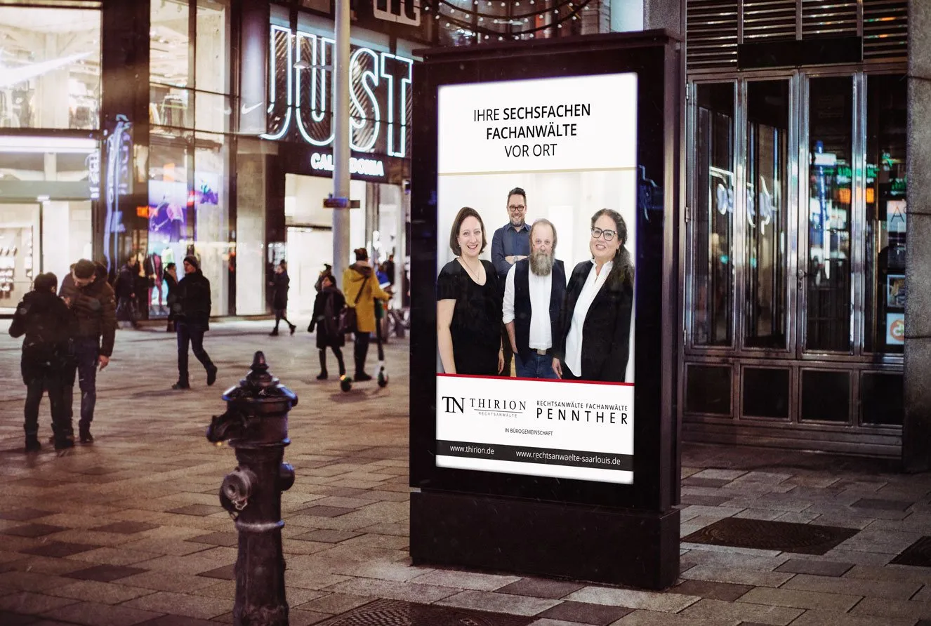 Beleuchtetes City-Light-Plakat der Kanzlei Thirion in der Innenstadt