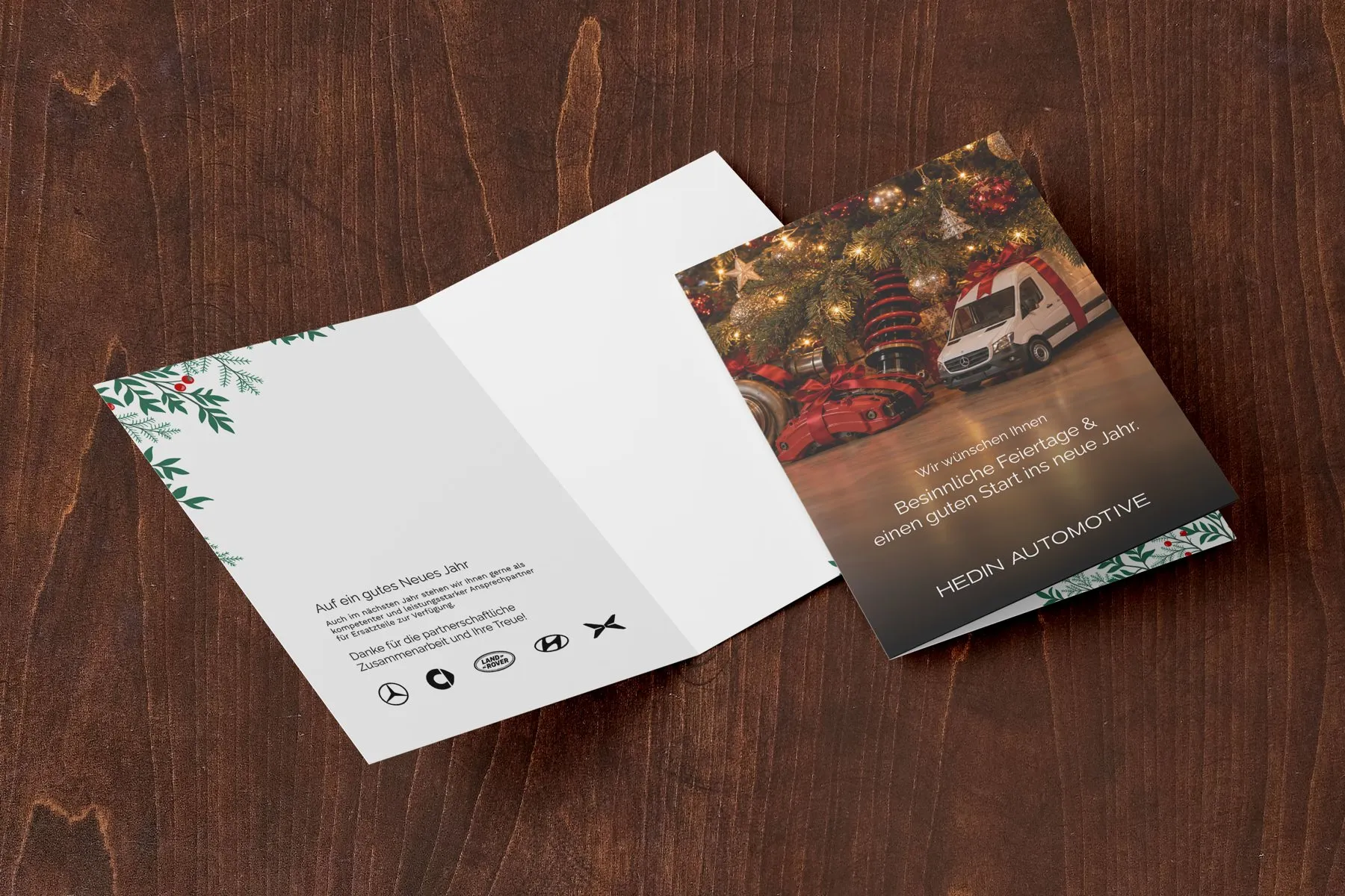 Aufgeklappte Weihnachtskarte von Hedin Automotive auf einem Holztisch
